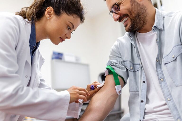 Healthcare worker drawing blood from a patient's arm in a clinical setting